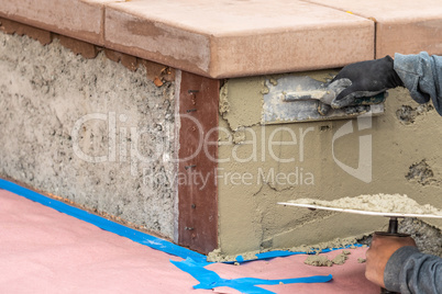 Tile Worker Applying Cement with Trowel at Pool Construction Site