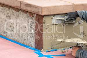 Tile Worker Applying Cement with Trowel at Pool Construction Site