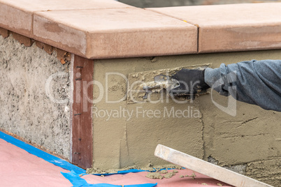 Tile Worker Applying Cement with Trowel at Pool Construction Sit