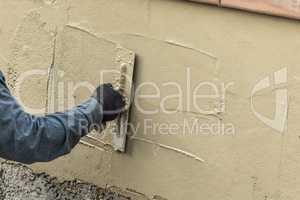 Tile Worker Applying Cement with Trowel at Pool Construction Site