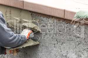 Tile Worker Applying Cement with Trowel at Pool Construction Site