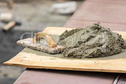 Wood Float Sitting Near Wet Cement On Board At Construction Site