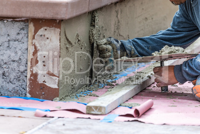 Tile Worker Applying Cement with Trowel at Pool Construction Sit