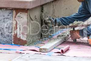 Tile Worker Applying Cement with Trowel at Pool Construction Sit