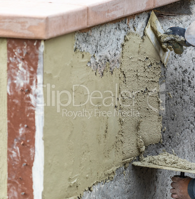 Tile Worker Applying Cement with Trowel at Pool Construction Sit