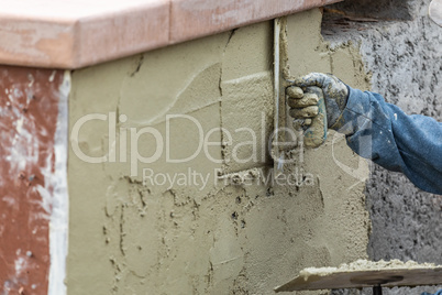 Tile Worker Applying Cement with Trowel at Pool Construction Sit