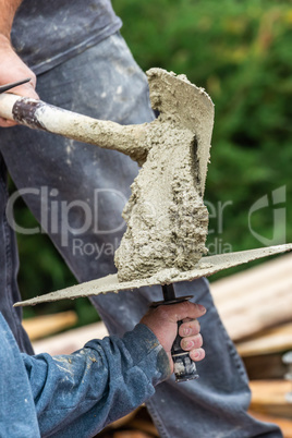 Construction Worker Placing Wet Cement On Platter For Tile Worker