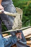 Construction Worker Placing Wet Cement On Platter For Tile Worker