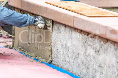 Tile Worker Applying Cement with Trowel at Pool Construction Sit