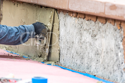 Tile Worker Applying Cement with Trowel at Pool Construction Site