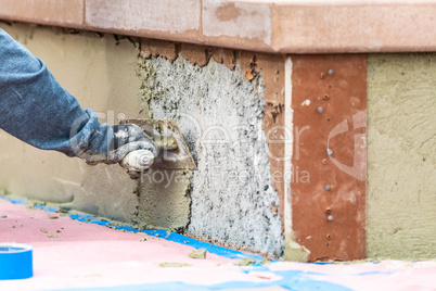 Tile Worker Applying Cement with Trowel at Pool Construction Sit