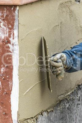 Tile Worker Applying Cement with Trowel at Pool Construction Site