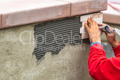 Worker Installing Wall Tile at Construction Site