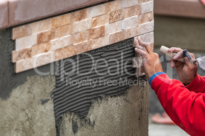 Worker Installing Wall Tile at Construction Site