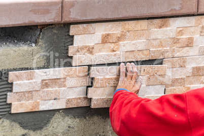 Worker Installing Wall Tile at Construction Site