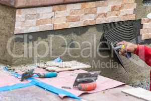 Worker Installing Wall Tile Cement with Trowel and Tile