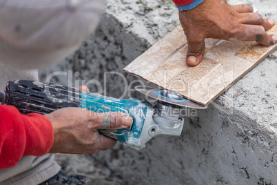 Worker Grinding Corner Tile for Fitting