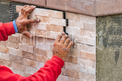 Worker Installing Wall Tile at Construction Site