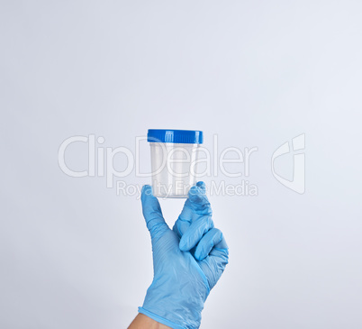 hand in a blue sterile glove holds a plastic container for colle