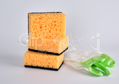 stack of yellow kitchen sponges for washing dishes and gloves