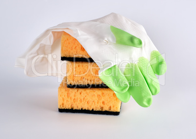 stack of yellow kitchen sponges for washing dishes and gloves