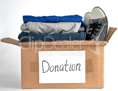 folded clothes in a brown paper box with the inscription donatio