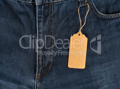 empty brown tag tied on a rope to blue jeans