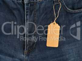 empty brown tag tied on a rope to blue jeans