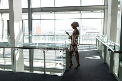 Side view of businesswoman using mobile phone in office lobby