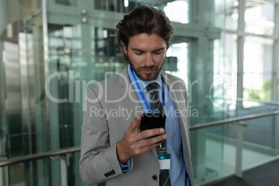 Caucasian businessman using mobile phone in the corridor at office