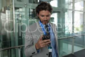 Caucasian businessman using mobile phone in the corridor at office