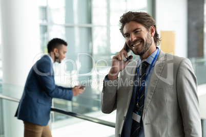 Caucasian businessman talking on mobile phone in the modern corridor