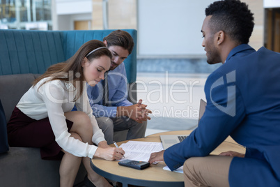 Caucasian businesswoman signing the contract papers in the lobby