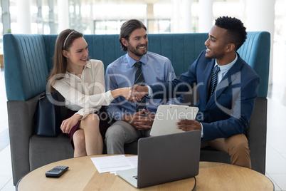 Multi-ethnic business people shaking hands with each other in the lobby