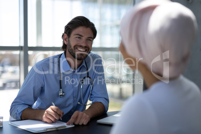Disabled mixed-race woman and Caucasian male doctor interacting with each other