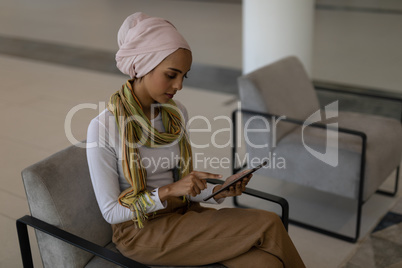 Young mixed-race female executive using digital tablet in modern office