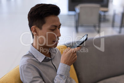 Asian male executive talking on mobile phone in the lobby