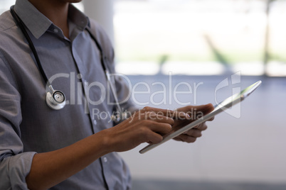 Asian male doctor using digital tablet in hospital