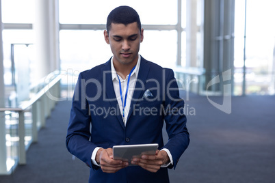 Mixed-race businessman using digital tablet in modern office