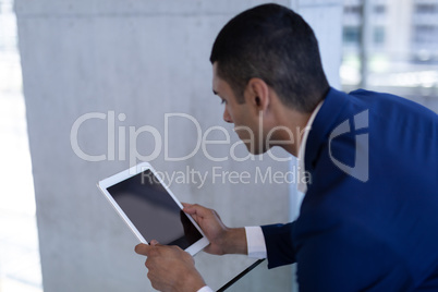 Youg mixed-race businessman using digital tablet in modern office