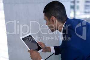 Youg mixed-race businessman using digital tablet in modern office