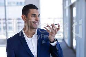 Young mixed-race businessman talking on mobile phone in modern office