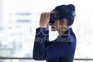 Young mixed-race businesswoman using virtual reality headset in modern office