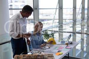 Caucasians architects interacting with each other at desk in office