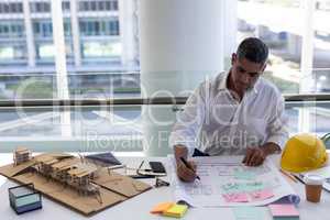 Mature Caucasian male architect working at desk