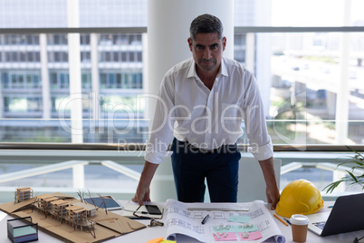 Mature Caucasian male looking at camera on desk