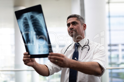 Caucasian male doctor looking at x-ray in clinic
