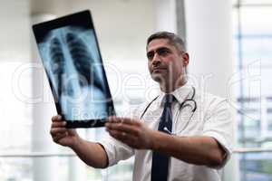 Caucasian male doctor looking at x-ray in clinic