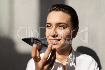 Young Caucasian businesswoman talking on mobile phone in office