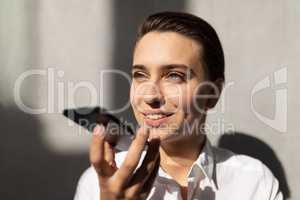 Young Caucasian businesswoman talking on mobile phone in office